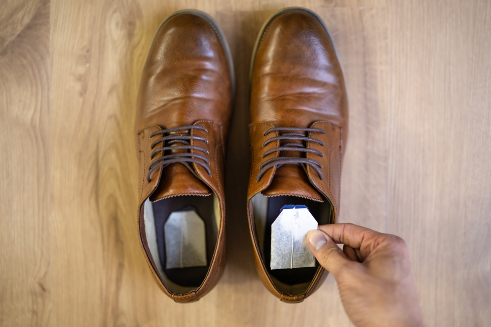 A pair of brown brogues with a tea bag in each.