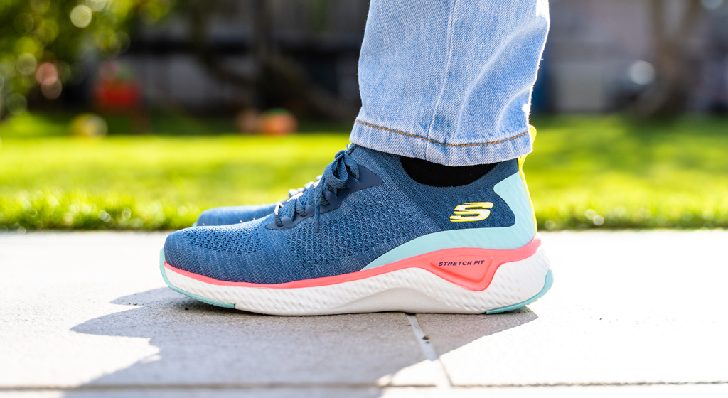 A side-view of blue & pink Skechers Stretch Fit.