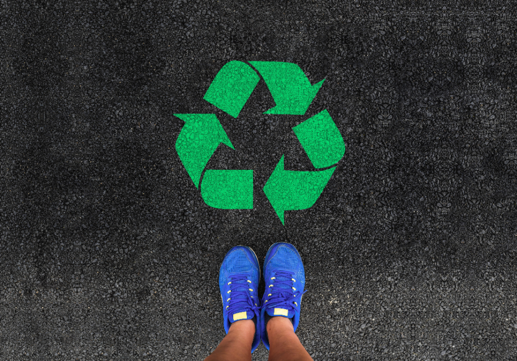 A birds-eye-view of trainers next to a green recycling logo.
