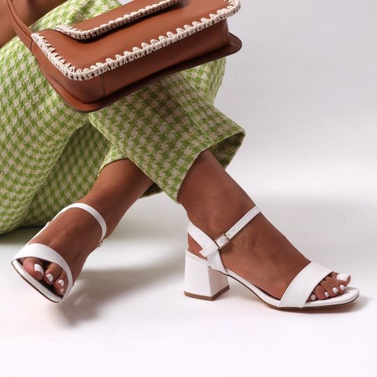 White block heels paired with green gingham pants and a tan-coloured bag.